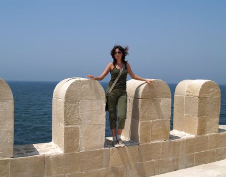 The girl on a old fortification on a background of the sea. Alexandria, Egipt