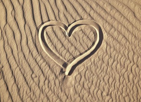 A photography of a heart in the sand