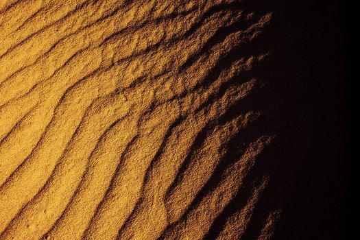 A photography of a sand texture fades to black