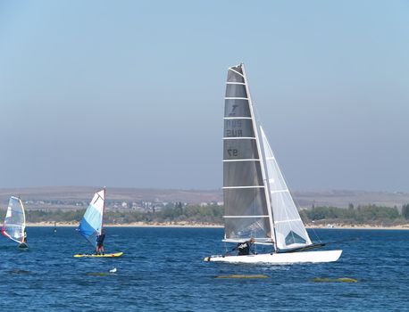 Sailing on calm blue water. Sailboat (yacht) cruising the ocean