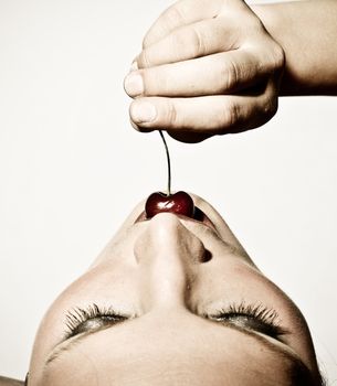 Closeup Upper View Of A Woman Sensually Tasting A Cherry