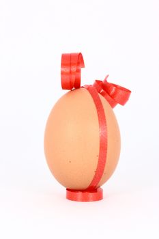 Chicken egg with decorations with red band