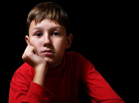 The thoughtful boy in a dark room