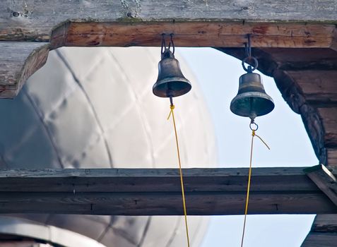 Two small bells on wooden orthodox church. Russia