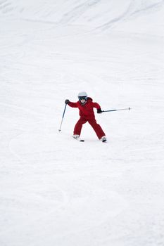 Young boy skiing down a snowy slope