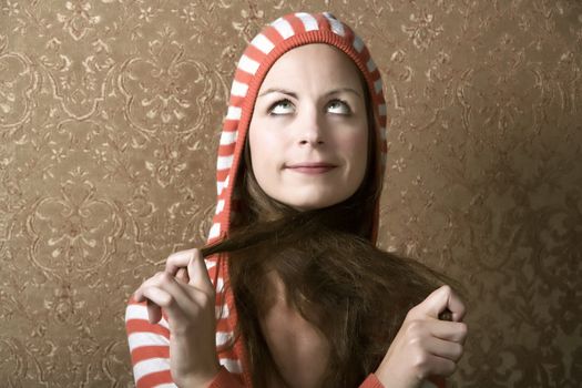 Young Woman in a Hooded Sweater Pulling on the Ends of Her Hair