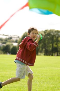 Boy running and laughing with a kite