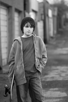 Moody skateboarder in an alleyway, black and white