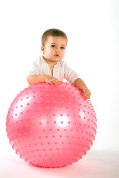 Thoughtful dark hired boy with pink fitness ball on white background