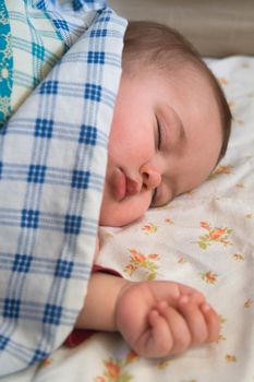 6 month old baby napping in the bed