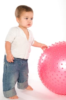 Thoughtful dark hired boy with pink fitness ball on white background