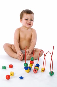 Boy sitting and laughing near his toys isolated on white