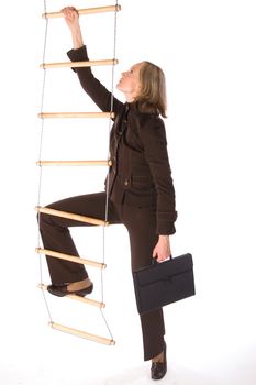 Young woman in brown suit climbing the career ladder isolated on white