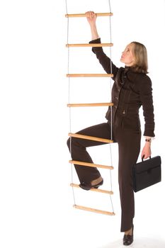 Young woman in brown suit climbing the career ladder isolated on white