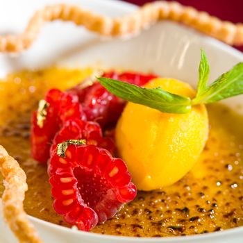 Cream caramel dessert with fresh sliced raspberry