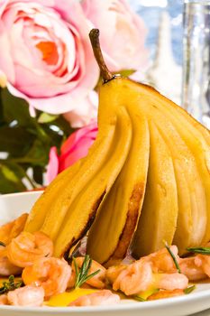 Sliced pear with prawn with roses on background