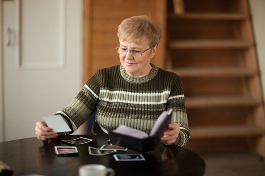 Senior woman viewing photo album in livingroom