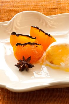 Ice cream and persimmon with anis star on plate