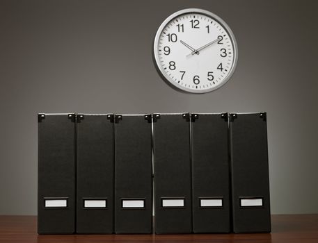 Folders in a row and a clock