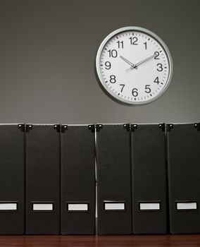 Folders in a row and a clock