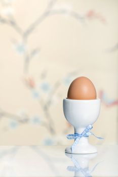 Egg in a white egg cup tied with a bow