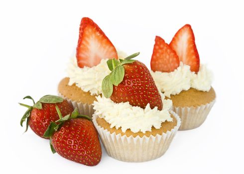 Selection of cupcakes decorated with cream and strawberries
