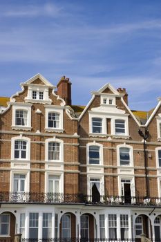 A row of victorian townhouses with a blue sky