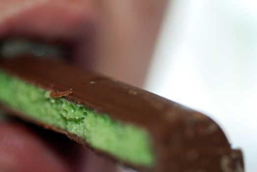 A photograph of a woman eating bubbly mint chocolate