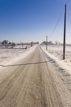 Straight rural road in winter. Sunny day in Poland