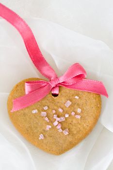 Gingerbread heart tied with a pink ribbon