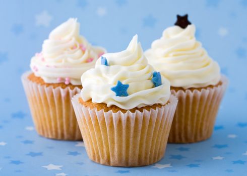 Trio of cupcakes against a blue starry background