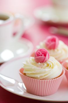 Pink rosebud cupcakes on a white plate