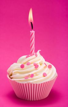 Pink birthday cupcake against a magenta background