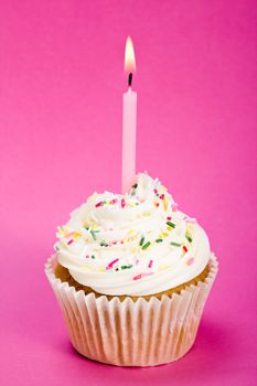 Birthday cupcake against a pink background