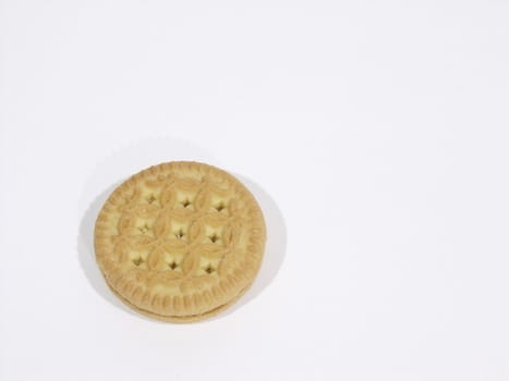 Single vanilla cookie lying on a white surface