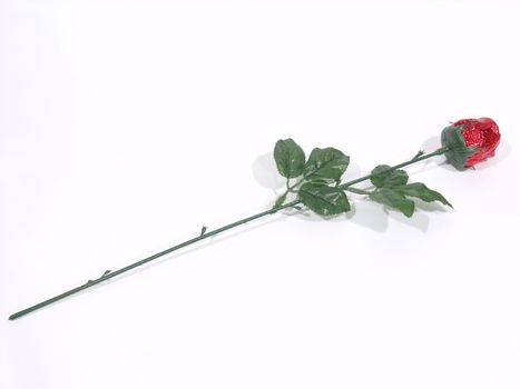 Isolated chocolate rose in a red wrapper on a white surface