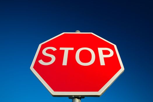 Stop sign against deep blue sky.