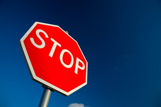 Stop sign against deep blue sky.