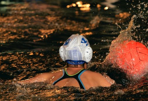 The floating child in water with sparks and red ball