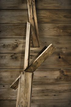 Close up detail of side of rustic wooden building with wood pieces hanging down.