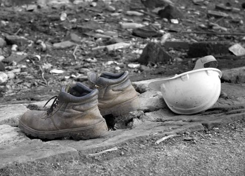 Pair of old work boots with builders hard hat,(selective color)