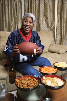 Portrait of smiling Middle-aged African-American woman wearing jersey and holding football.