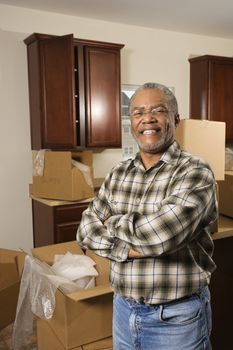Portrait of middle-aged African-American male in kitchen with moving boxes.