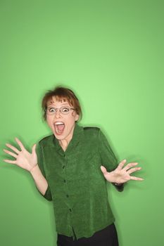 Smiling Caucasian mid-adult woman gesturing on green background.