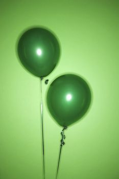 Still life of green balloons on green background.