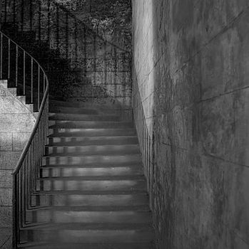 Monochrome shot of sandstone shadowy staircase with rusted handrail (circa 1854)