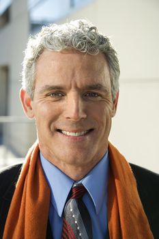 Close up of prime adult Caucasian man in suit looking at viewer smiling.