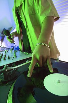 Close-up of Asian young adult male DJ's hand spinning vinyl record.