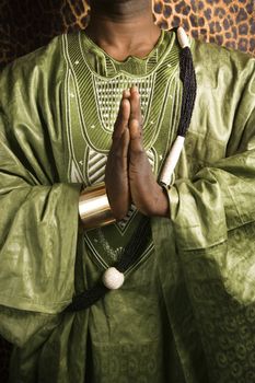 Close-up of African-American mid-adult man wearing traditional African clothing in prayer.