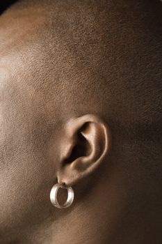 Side view portrait of African-American mid-adult man wearing earring.